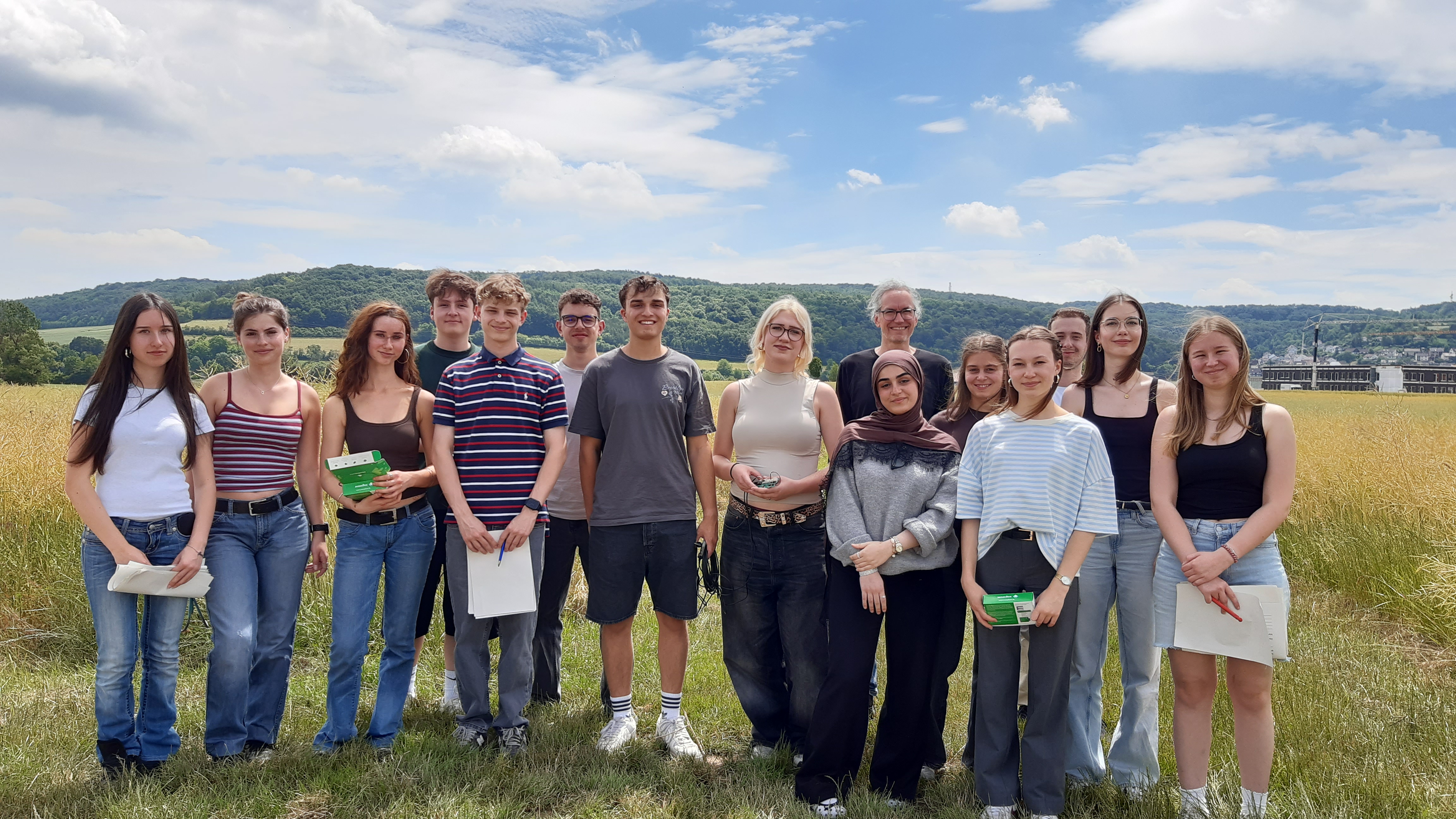 Schülerinnen und Schüler der Leistungsfächer Geographie und Biologie des Frobenius-Gymnasiums mit Messgeräten auf einem Feld bei Hammelburg