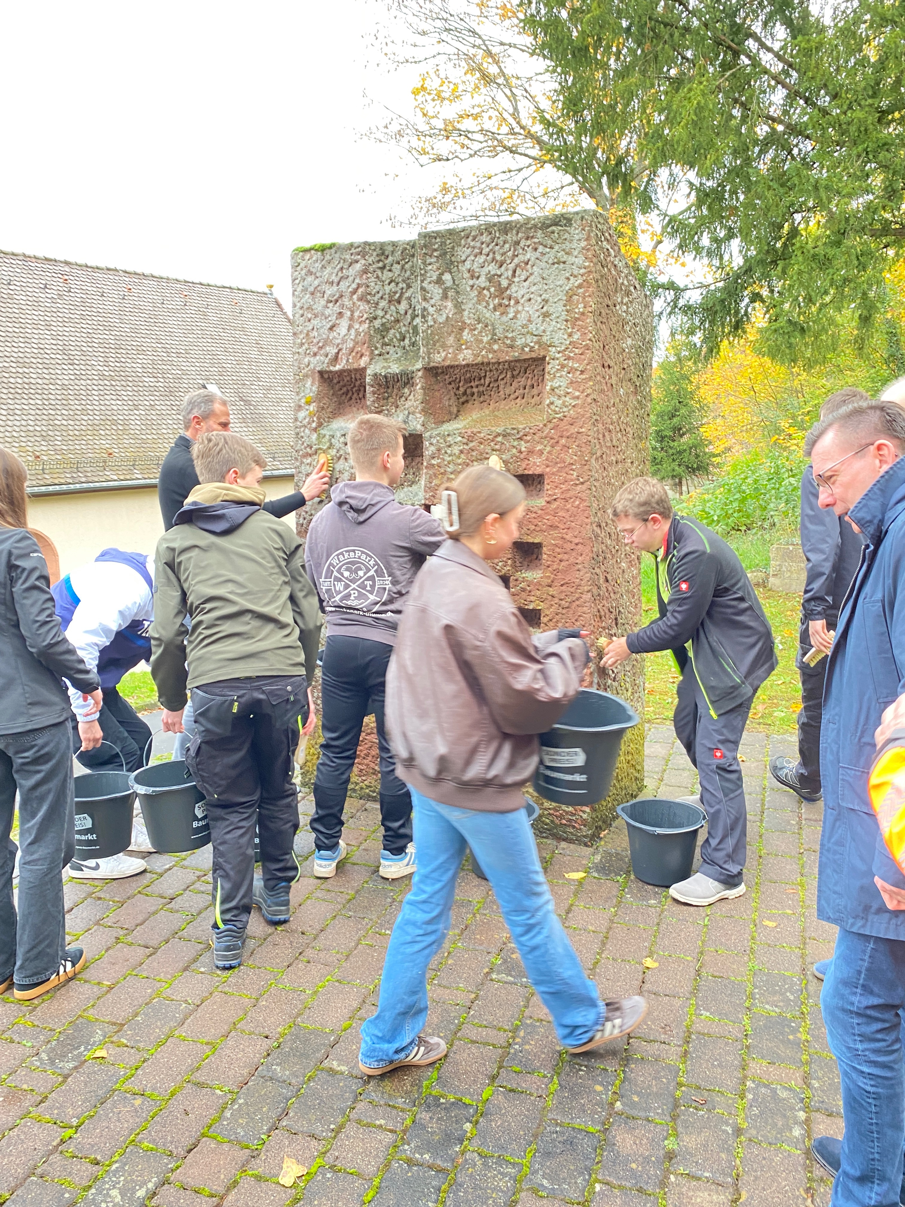 Schülerinnen und Schüler reinigen das Kriegerdenkmal in Pfaffenhausen